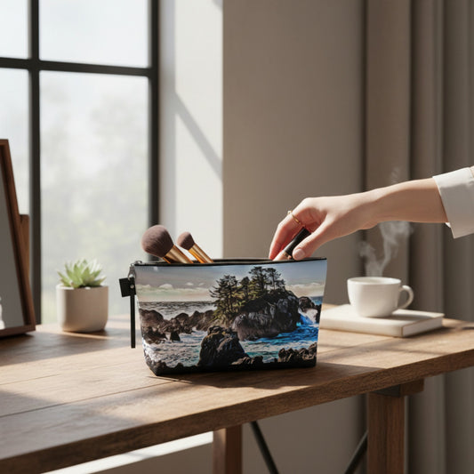 Hand reaching for a makeup bag with a nature print on a wooden desk.