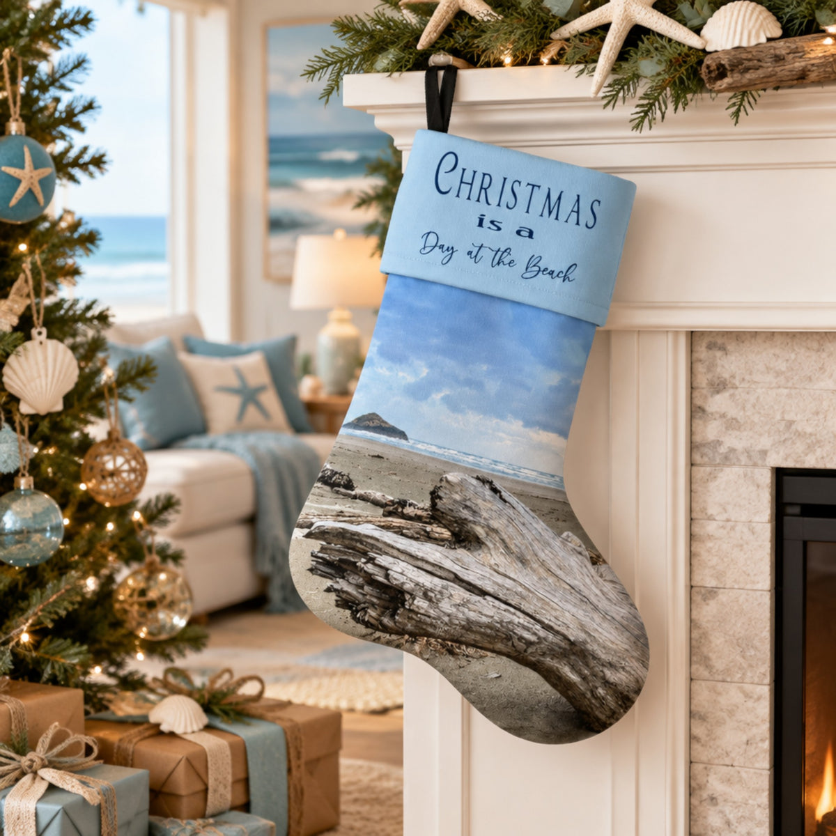 A personalized Christmas stocking with a beach print hangs from a white fireplace mantel decorated with a green pine garland, starfish, and shells. The stocking features a light blue top section with the text 'Christmas is a Day at the Beach' and a lower section showing a beach scene with driftwood and ocean waves.