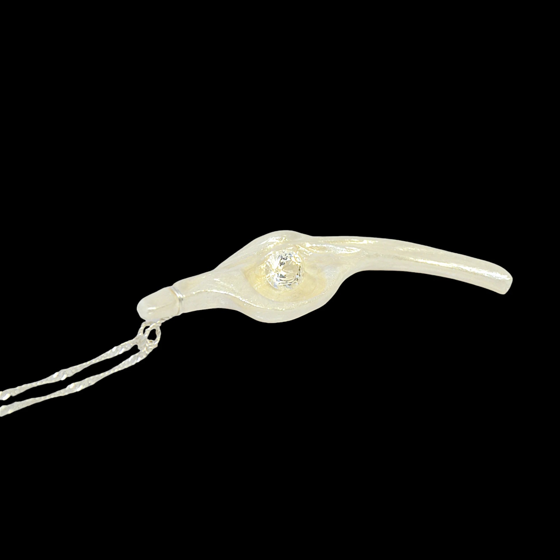 Diamond Star natural seashell pendant with eight mm faceted herkimer diamond. The pendant is laying down with a black background.