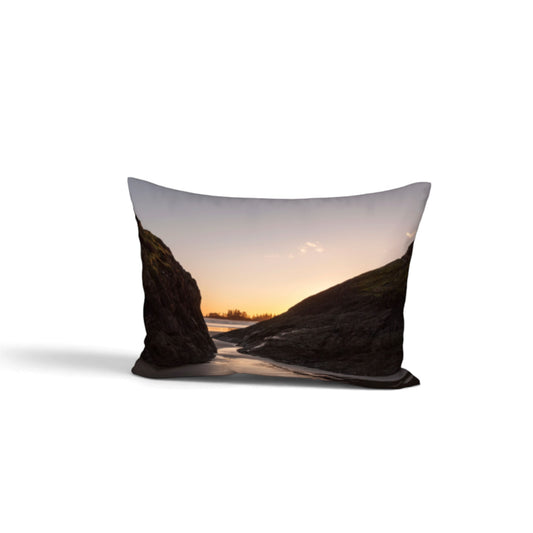 A rectangular bed pillow featuring a scenic landscape print of a rocky coastline at sunset, shown against a plain white background.