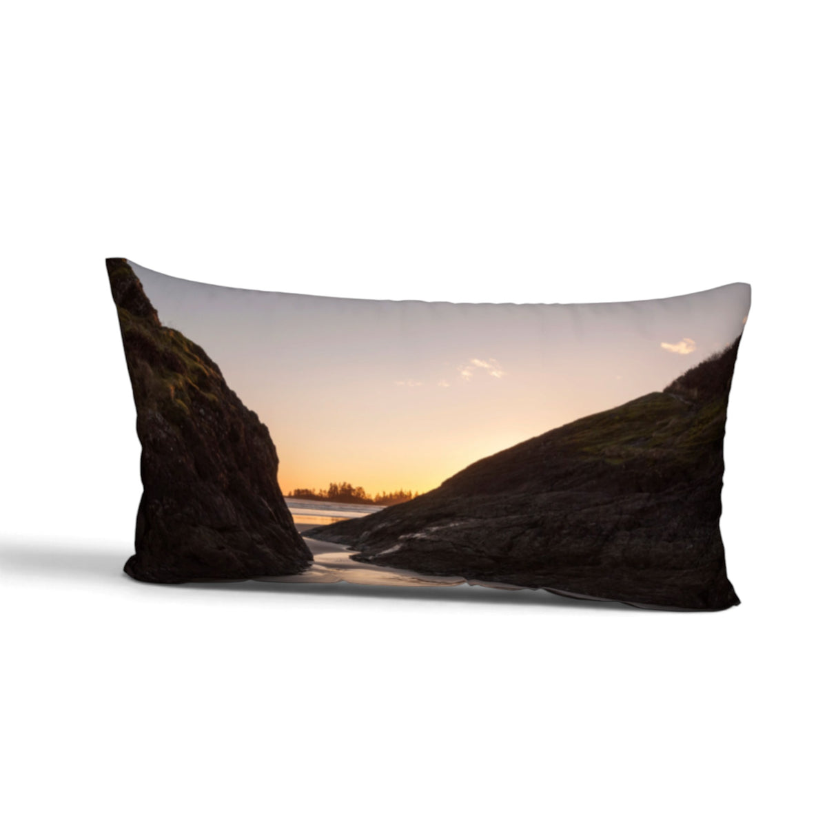 A rectangular bed pillow featuring a scenic landscape print of a rocky coastal inlet at sunset, shown against a plain white background.