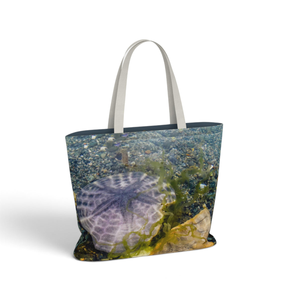 A tote bag featuring an underwater sand dollar shell and green seaweed print, with light gray shoulder straps, shown on a white background.