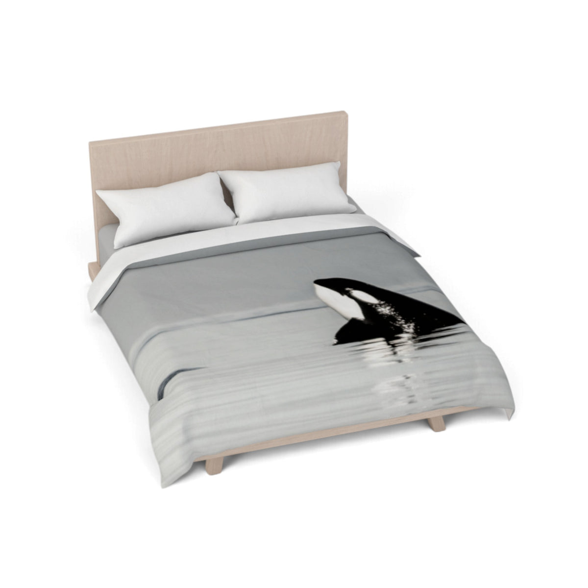A bed with a gray and white duvet cover featuring a black and white orca whale print, styled with two white pillows and a light wood headboard on a white background.