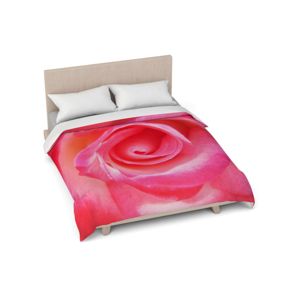 A bed with a large pink rose print duvet cover and two white pillows, shown on a light wood bed frame against a plain white background.