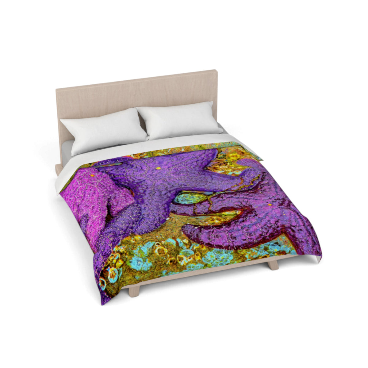 A bed with a colorful abstract print comforter featuring a purple starfish design with turquoise, gold, and pink details, styled with two white pillows on a light wood bed frame against a white background.