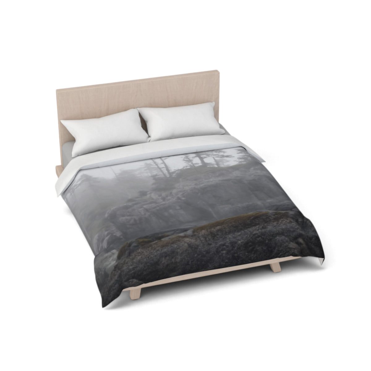 A bed with a duvet cover featuring a moody, misty forest landscape print in shades of gray, black, and white, styled with two white pillows and a light wood headboard on a white background.