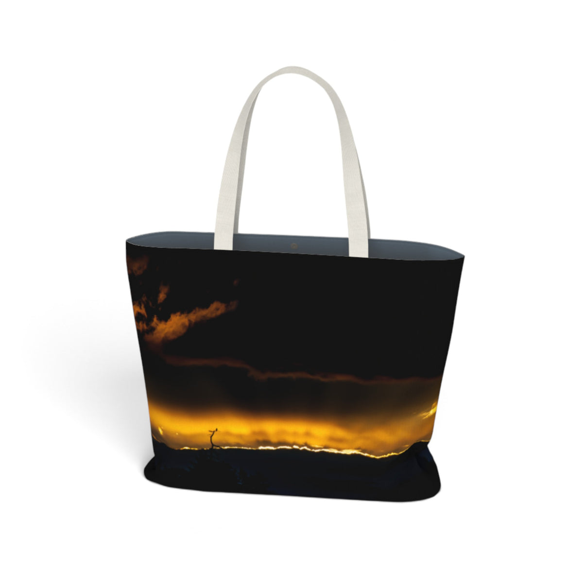 A tote bag with a dark sky and golden sunset landscape print, featuring white shoulder straps, shown on a plain white background.