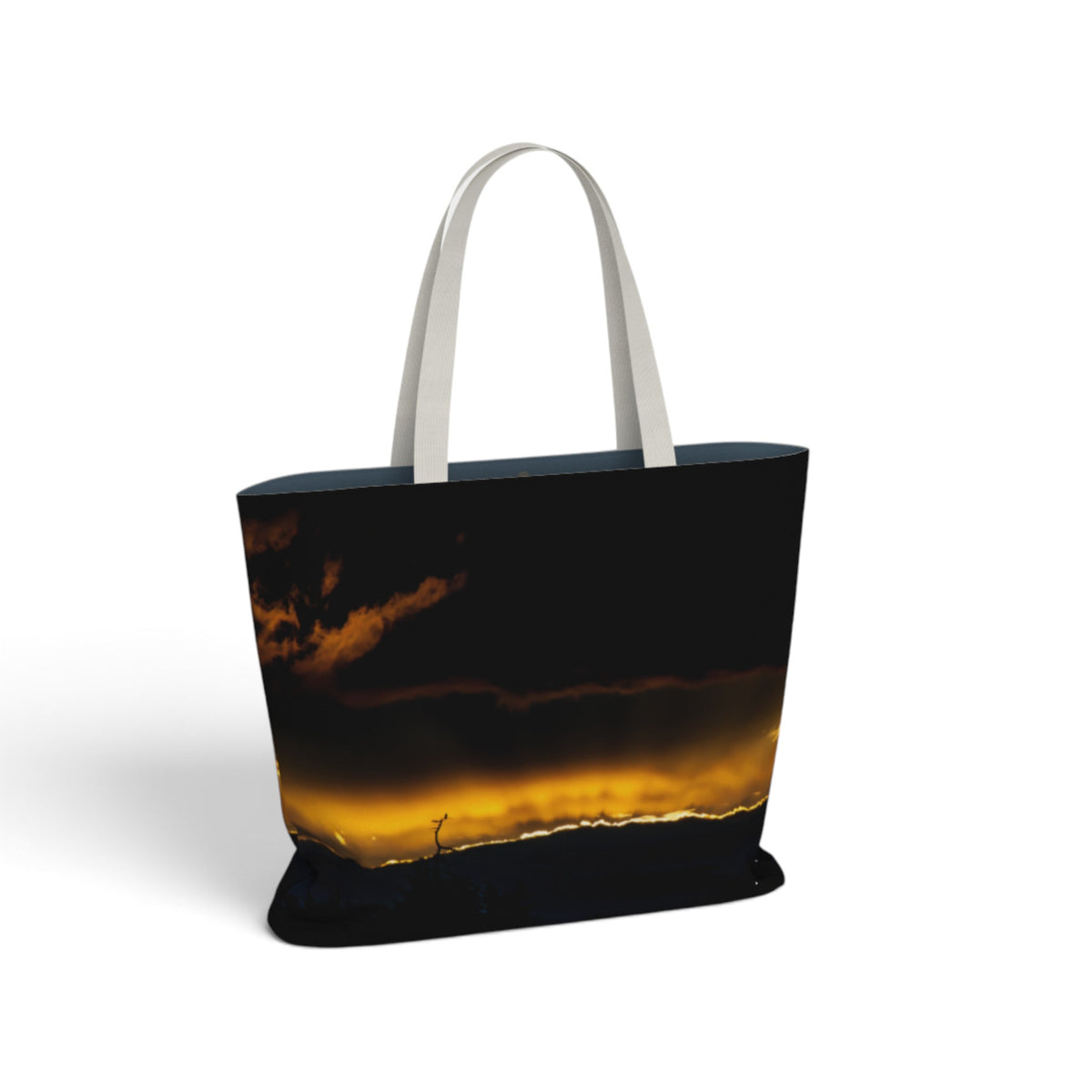 A tote bag with a dark sky and golden sunset print, featuring light gray fabric shoulder straps, shown on a plain white background.