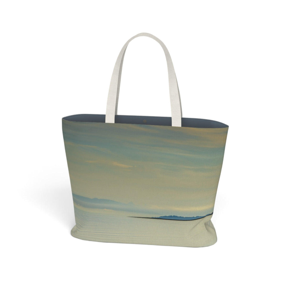 A tote bag featuring a printed landscape design with soft blue, beige, and gray tones, complete with two cream-colored shoulder straps, shown against a plain white background.