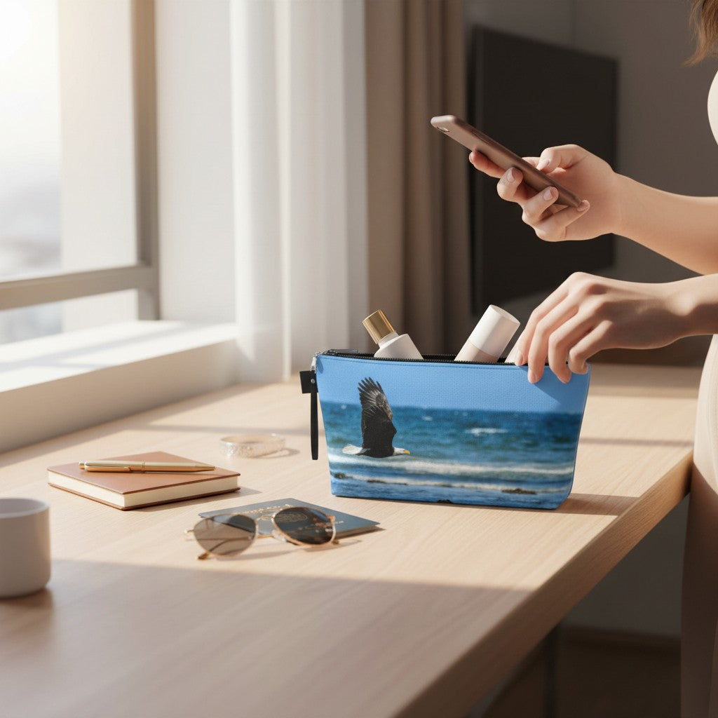 Person using a smartphone with a blue pouch on a desk featuring a scenic design.