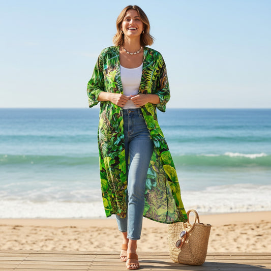 Woman in a green patterned kimono standing on a beach with ocean in the background