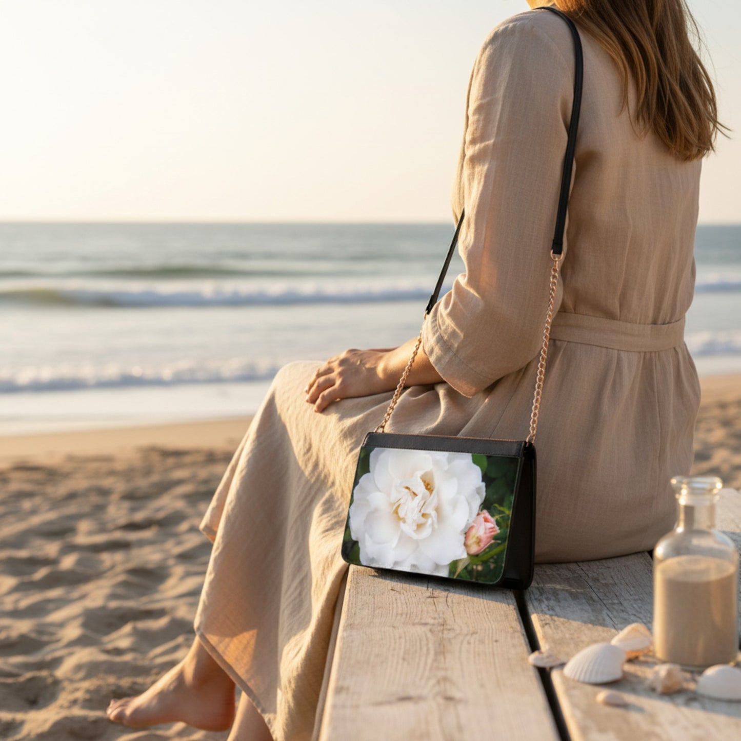 Woman sitting on a beach with a floral handbag