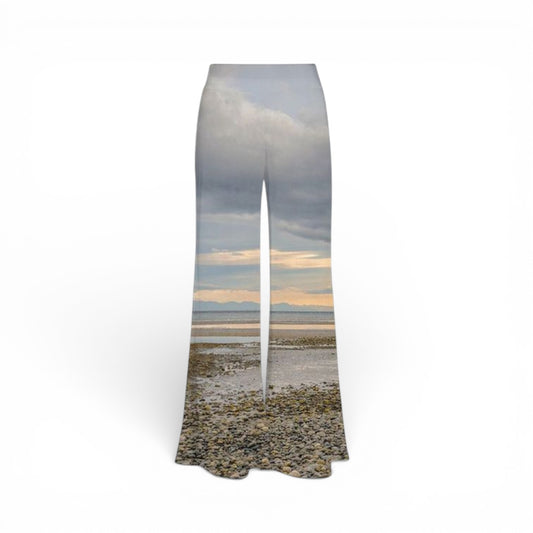 Pants with a scenic print of a beach and sky on a white background