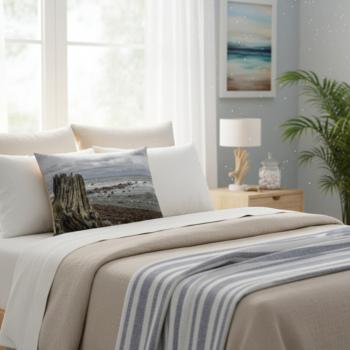 A throw pillow with an image of a tree stump on a beach with a cloudy sky in the background.
