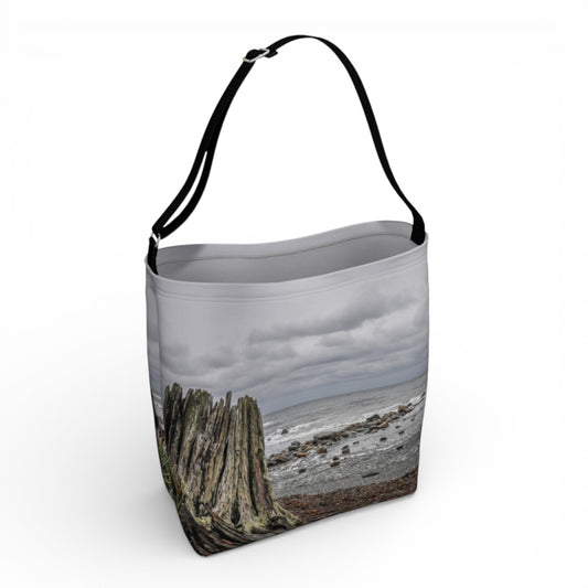 Tote bag featuring a ocean view with a old stump on the beach.