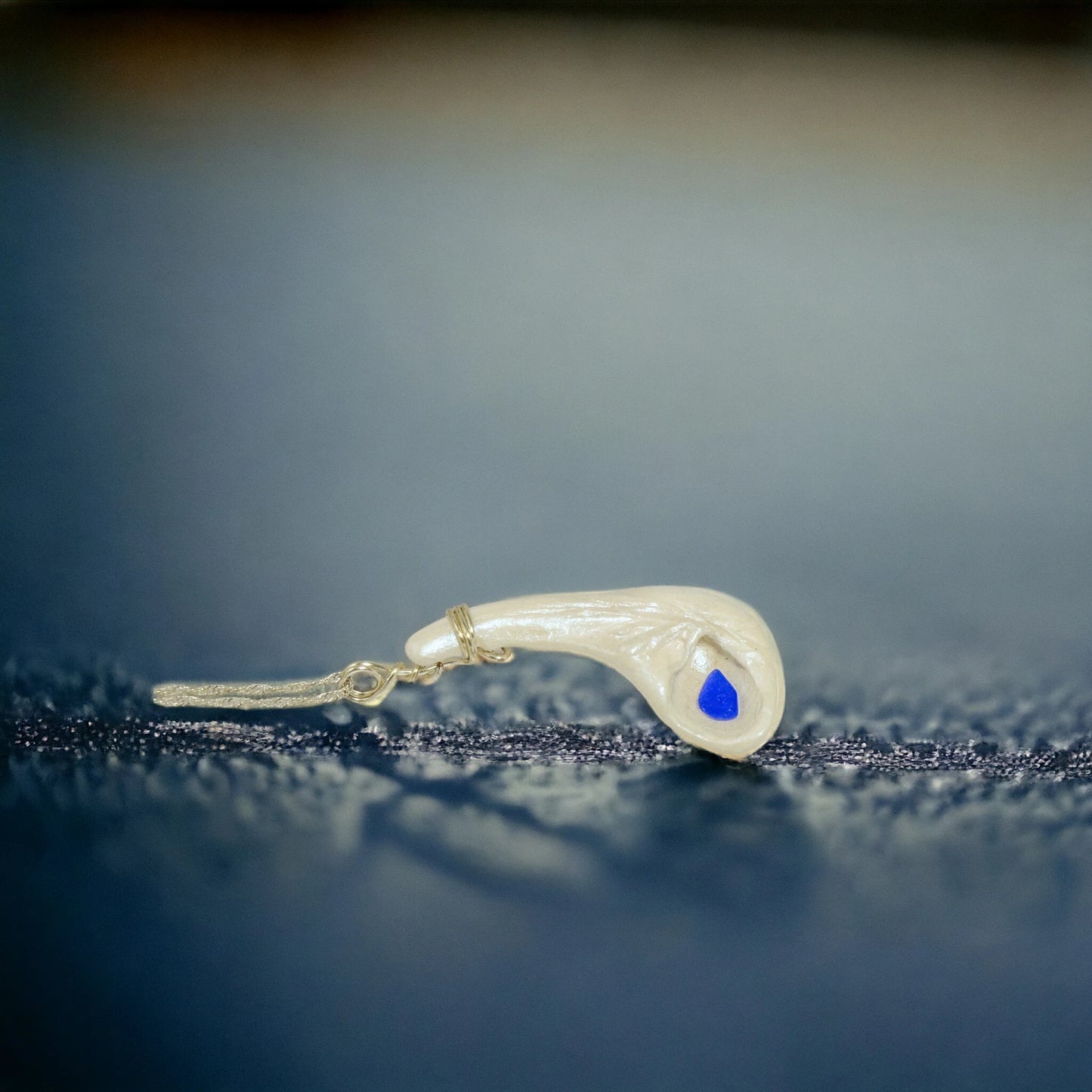 The pendant is shown on its side to give the viewer a different way to see the pendant.  The background is dark blue