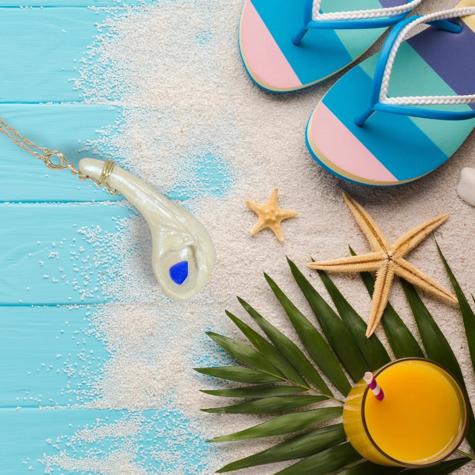 The beautiful blue of the sea glass in this pendant called Cobalt would be a perfect addition to your summer wardrobe.  The pendant is shown on a deck with complimentary coloured sandals, starfish, sand and a refreshing orange drink.  Summer vibes.
