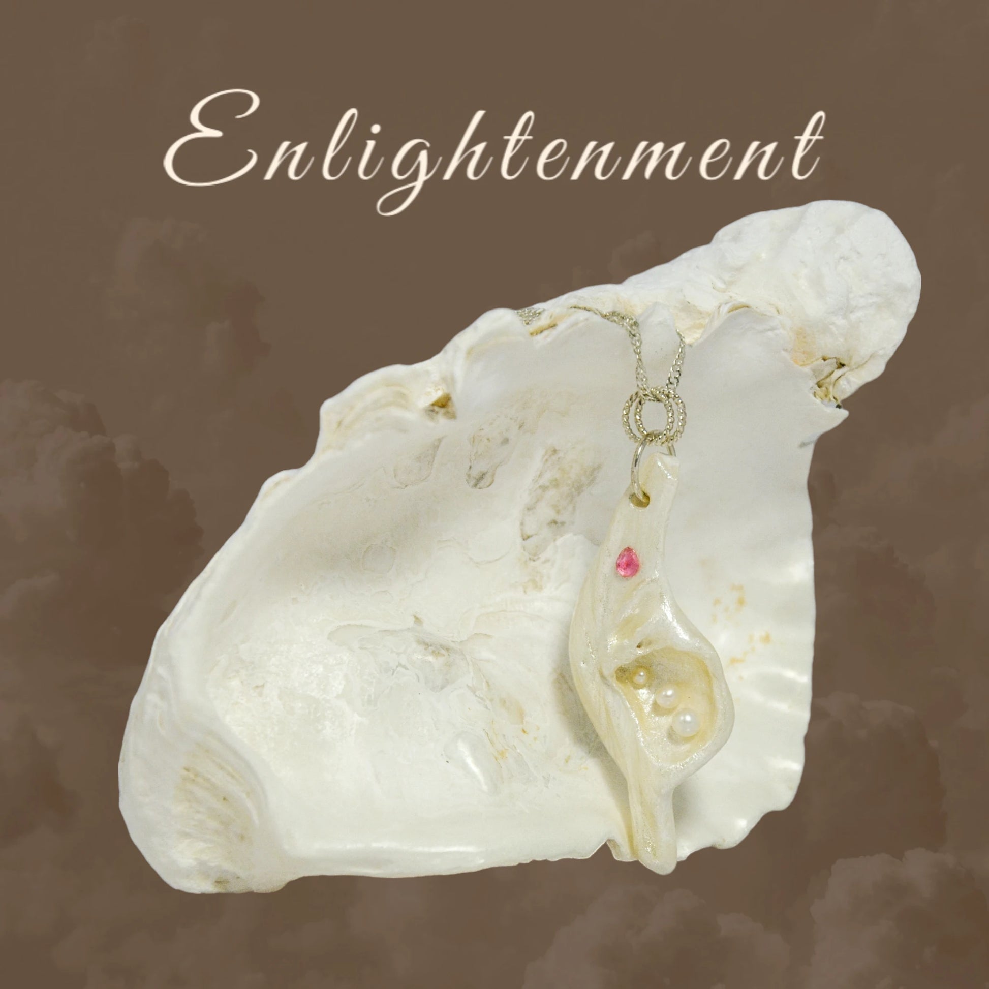 A trio of white baby freshwater pearls and a teardrop rose cut pink tourmaline gemstone compliments the seashell pendant beautifully. The pendant is shown hanging on a larger seashell.  The word enlightenment is printed at the top of the image.