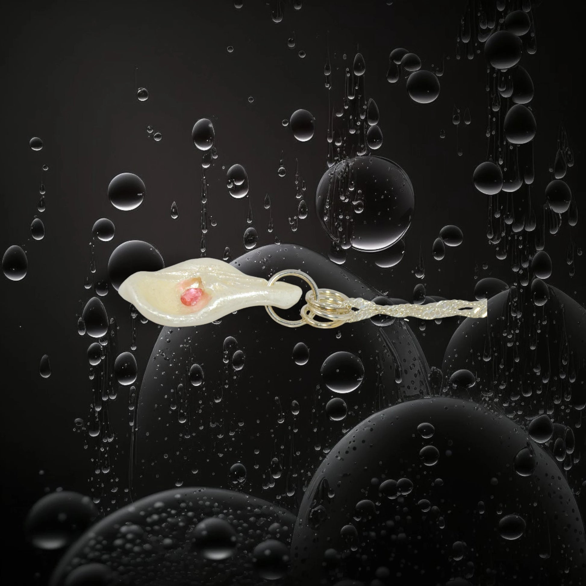 Jewel natural seashell with a real teardrop shaped rose cut pink tourmaline gemstone compliments the pendant. The pendant is shown on its side with a black background with water bubbles.