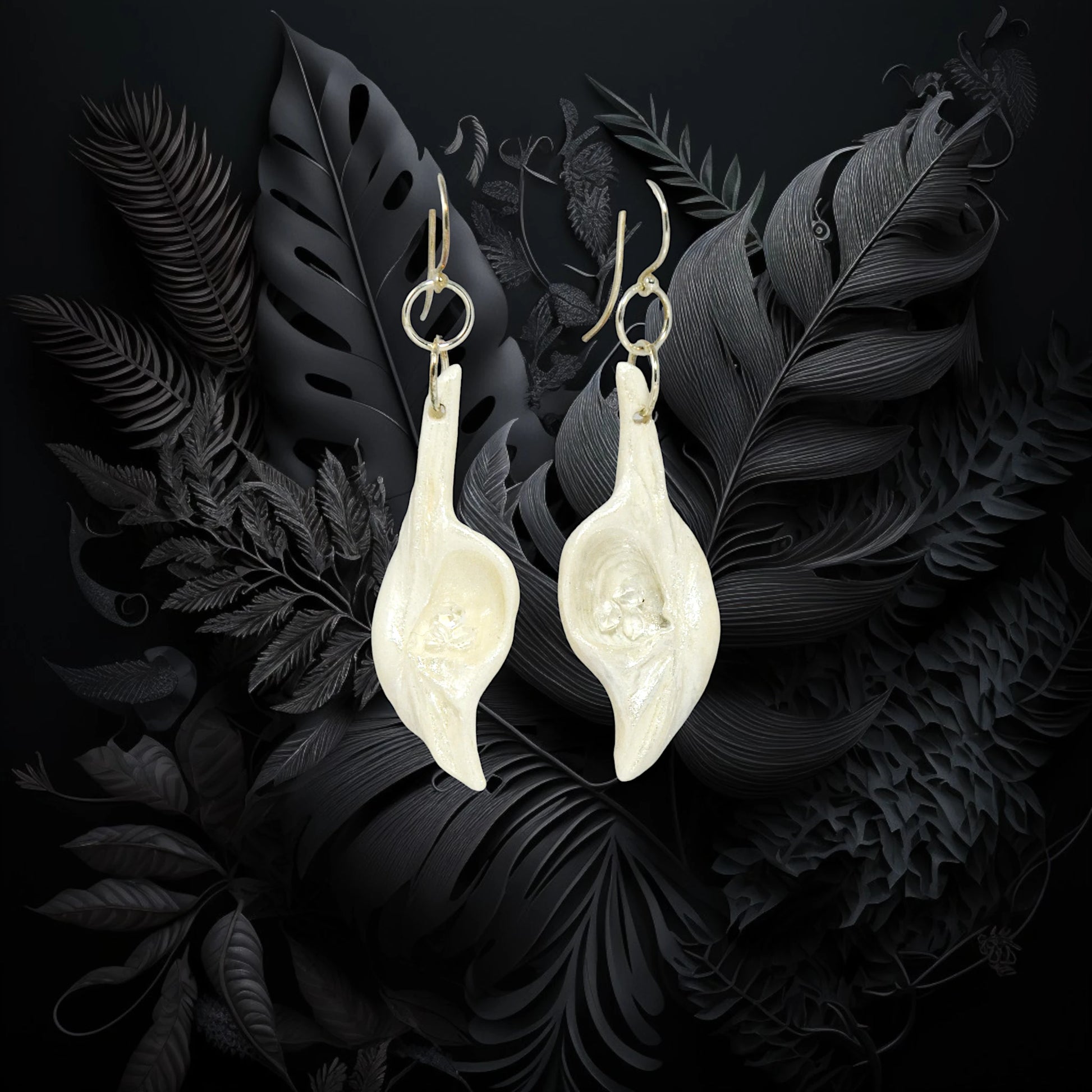 Dream Stone natural seashell earrings with herkimer diamonds. The earrings are shown on a black background.