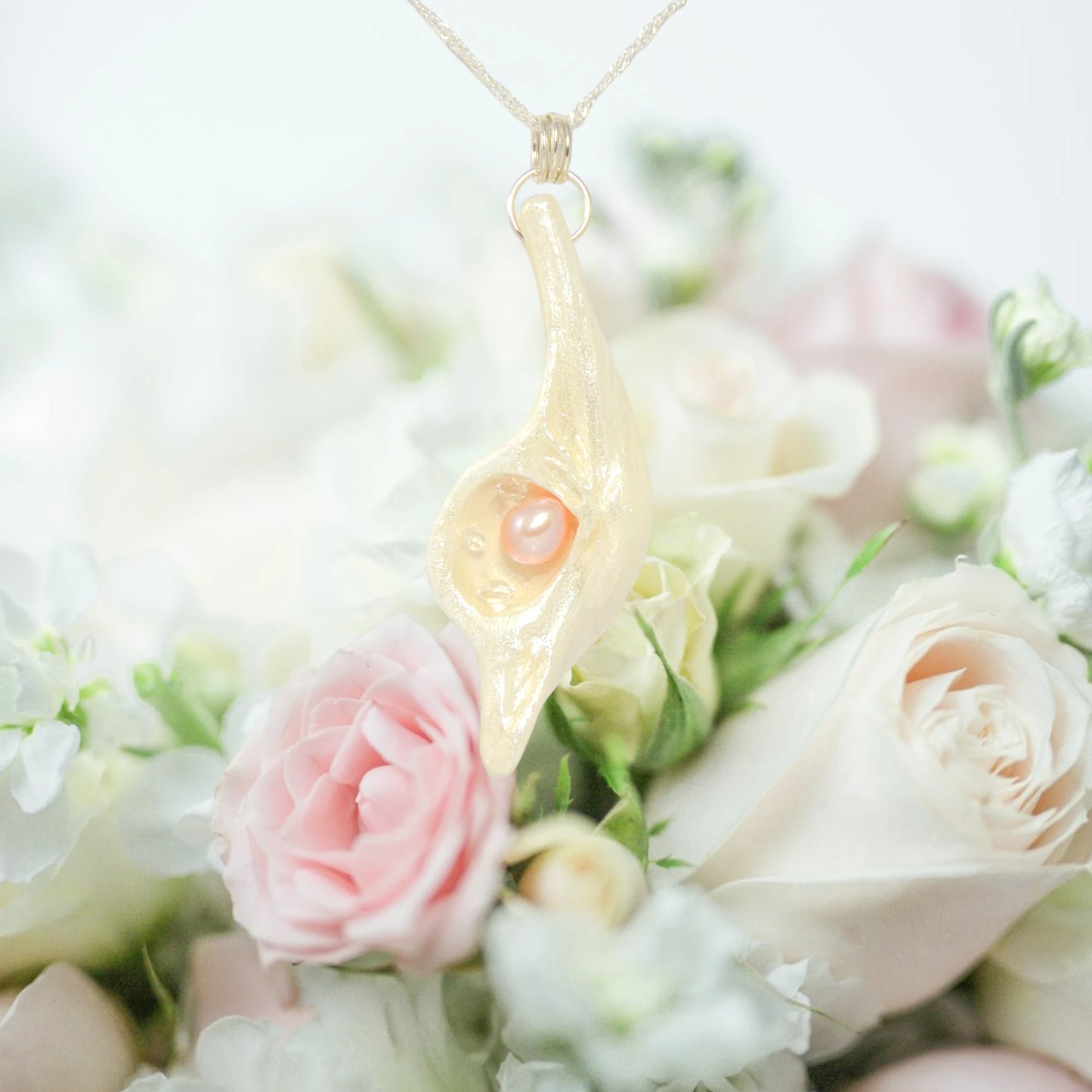 The pendant champagne on ice is shown hanging from a necklace over a beautiful bouquet of pink and white rose.  Special occasions come to mind wedding, engagement, birthday, anniversary, bridesmaid, Christmas, Valentines .