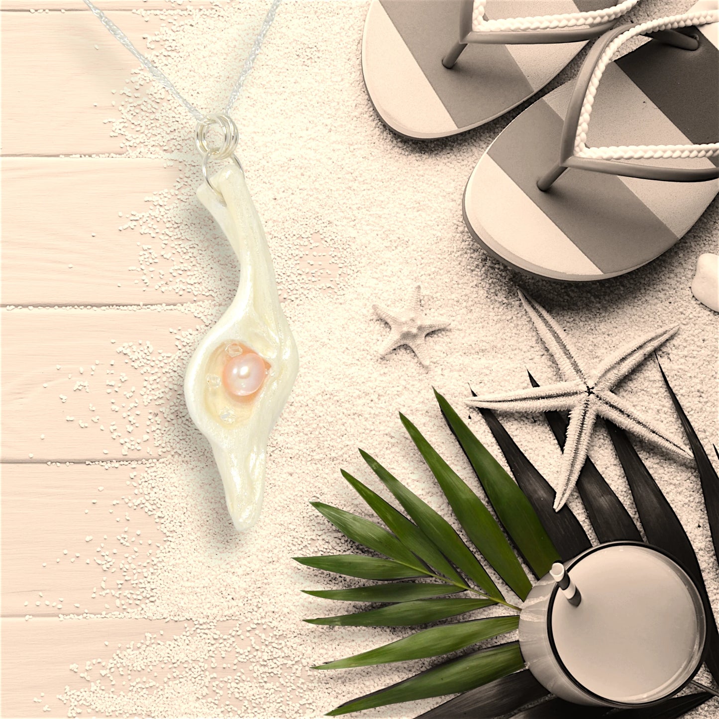 The pendant champagne on ice compliments any season but especially the summer!  The pendant is shown on a deck floor with sand, starfish, sandals and a summer refreshment.