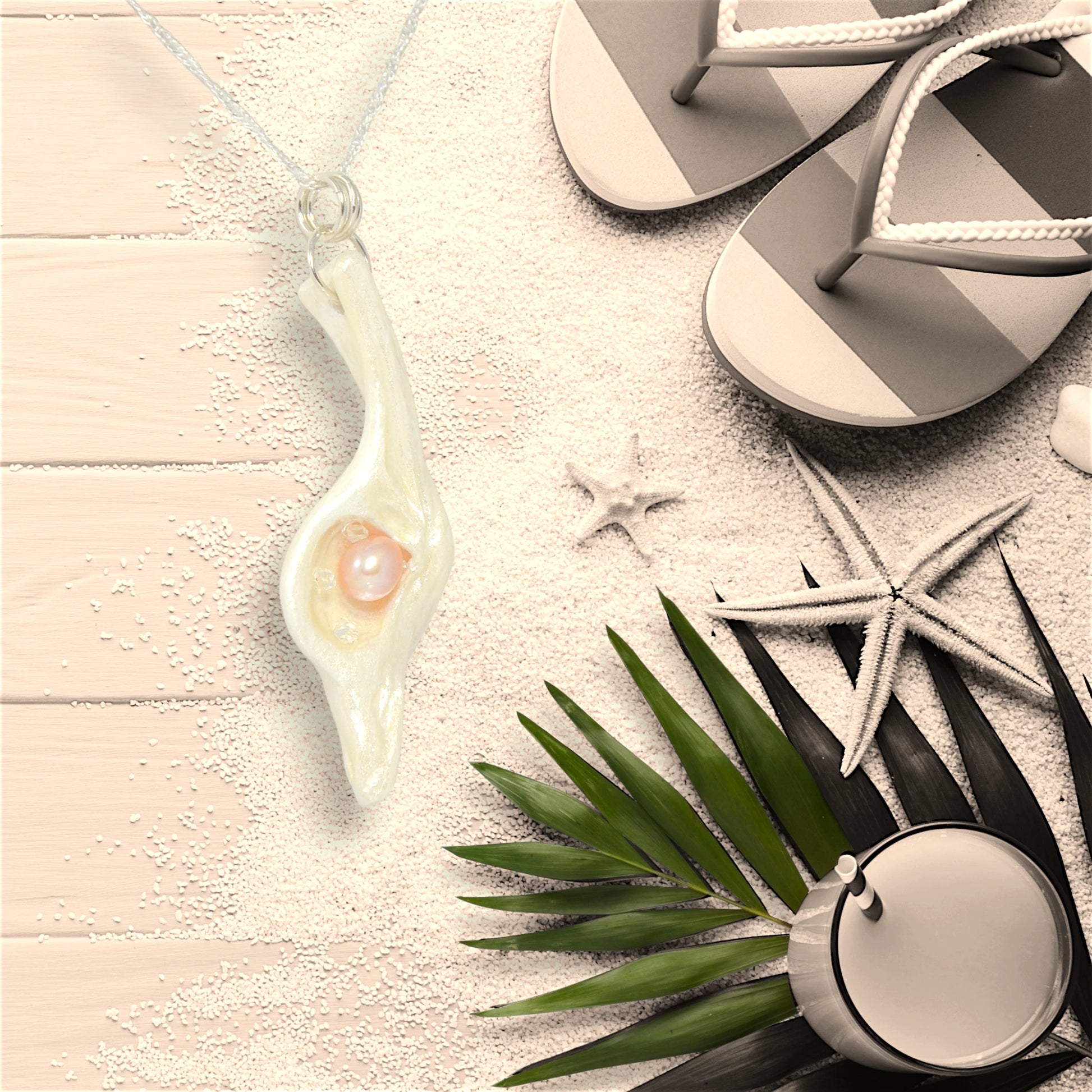 The pendant champagne on ice compliments any season but especially the summer!  The pendant is shown on a deck floor with sand, starfish, sandals and a summer refreshment.