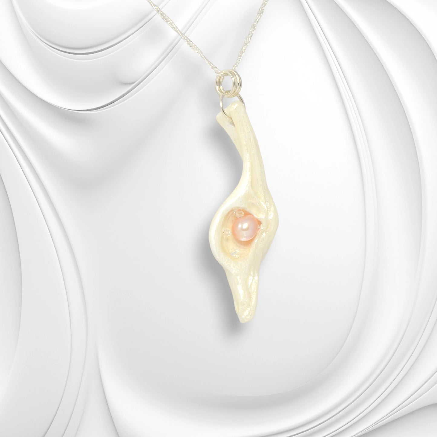 The pendant Champagne on Ice is shown on a wavy white background.  The pendant is turned slightly to the right to show the unique shape of the pendant.