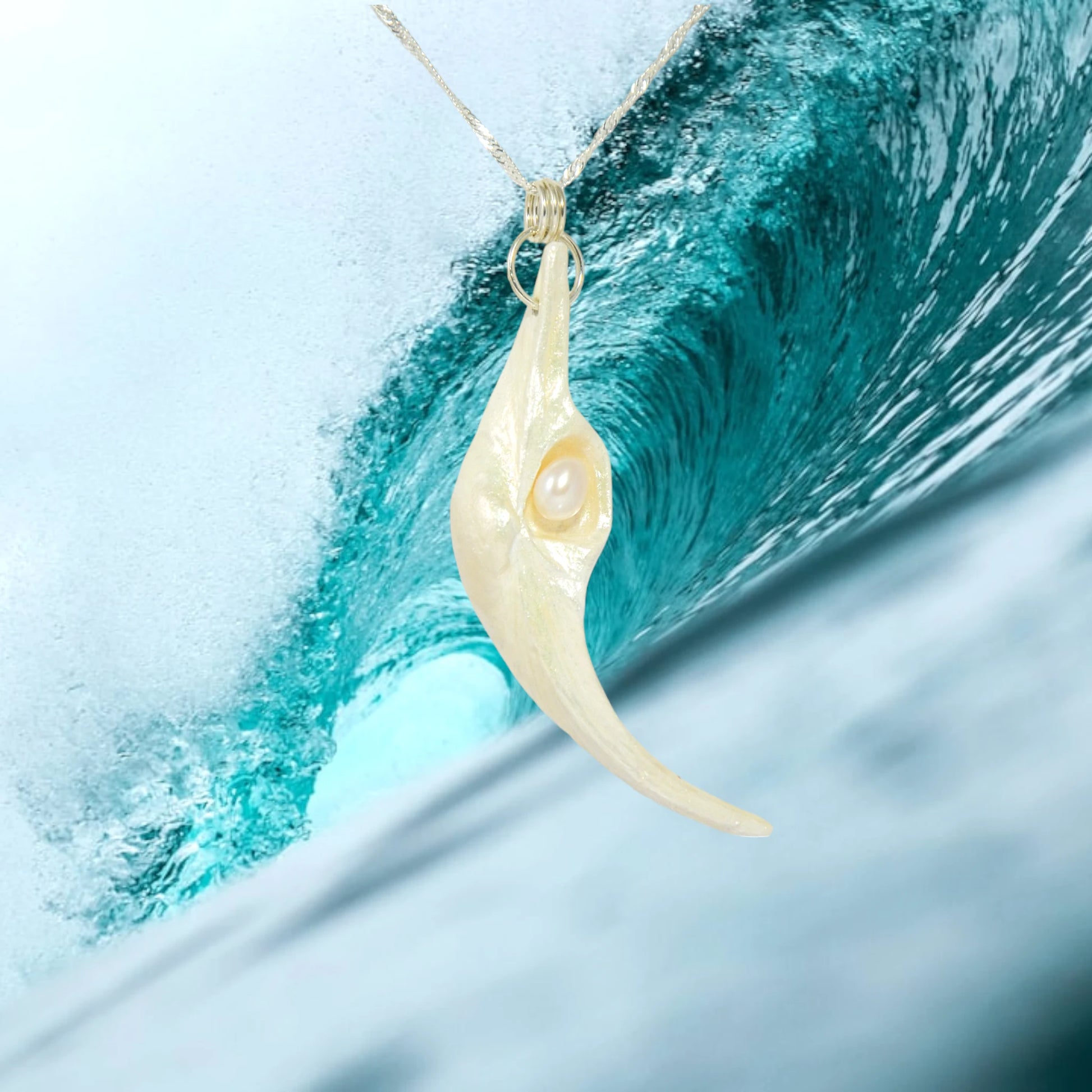 Jupiter is a natural seashell pendant with a real freshwater pearl. The background is of a ocean wave.