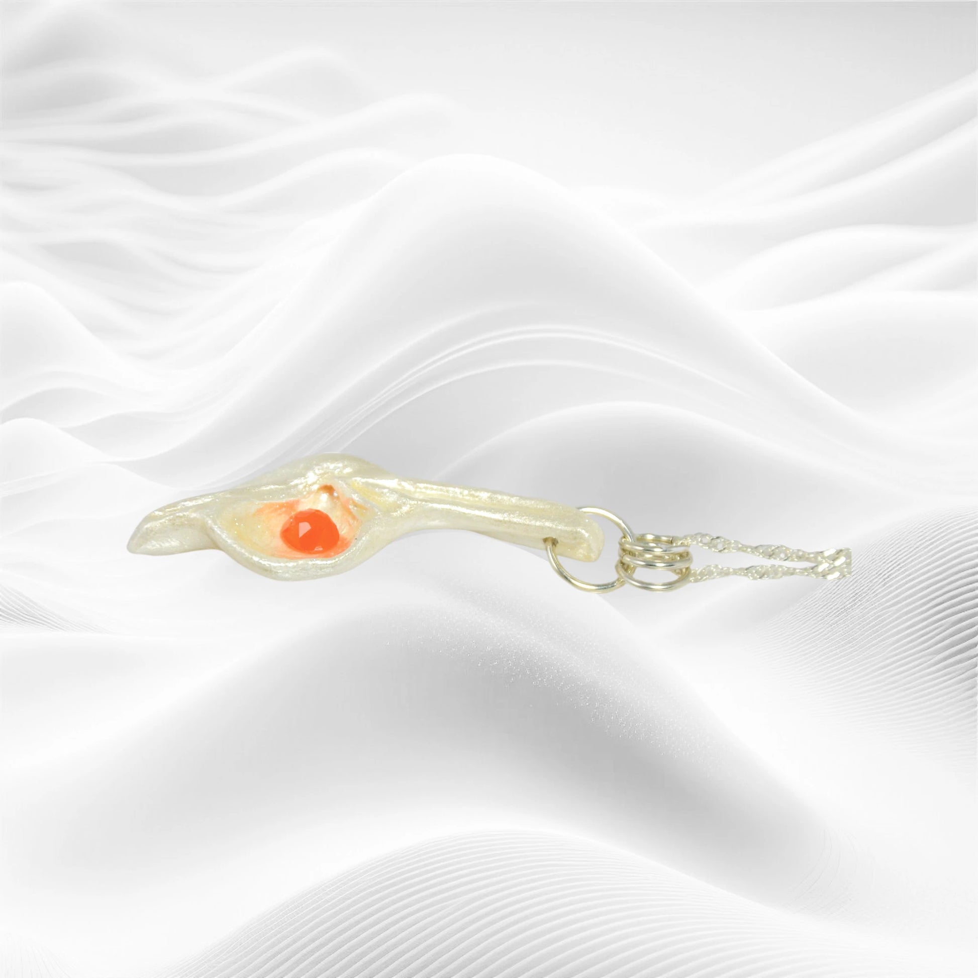 Natural Seashell pendant, elevating the beautiful natural nuances to new heights. The pendant is perfectly adorned with a mesmerizing rose cut Carnelian gemstone. The pendant is laying on a white wavy background.