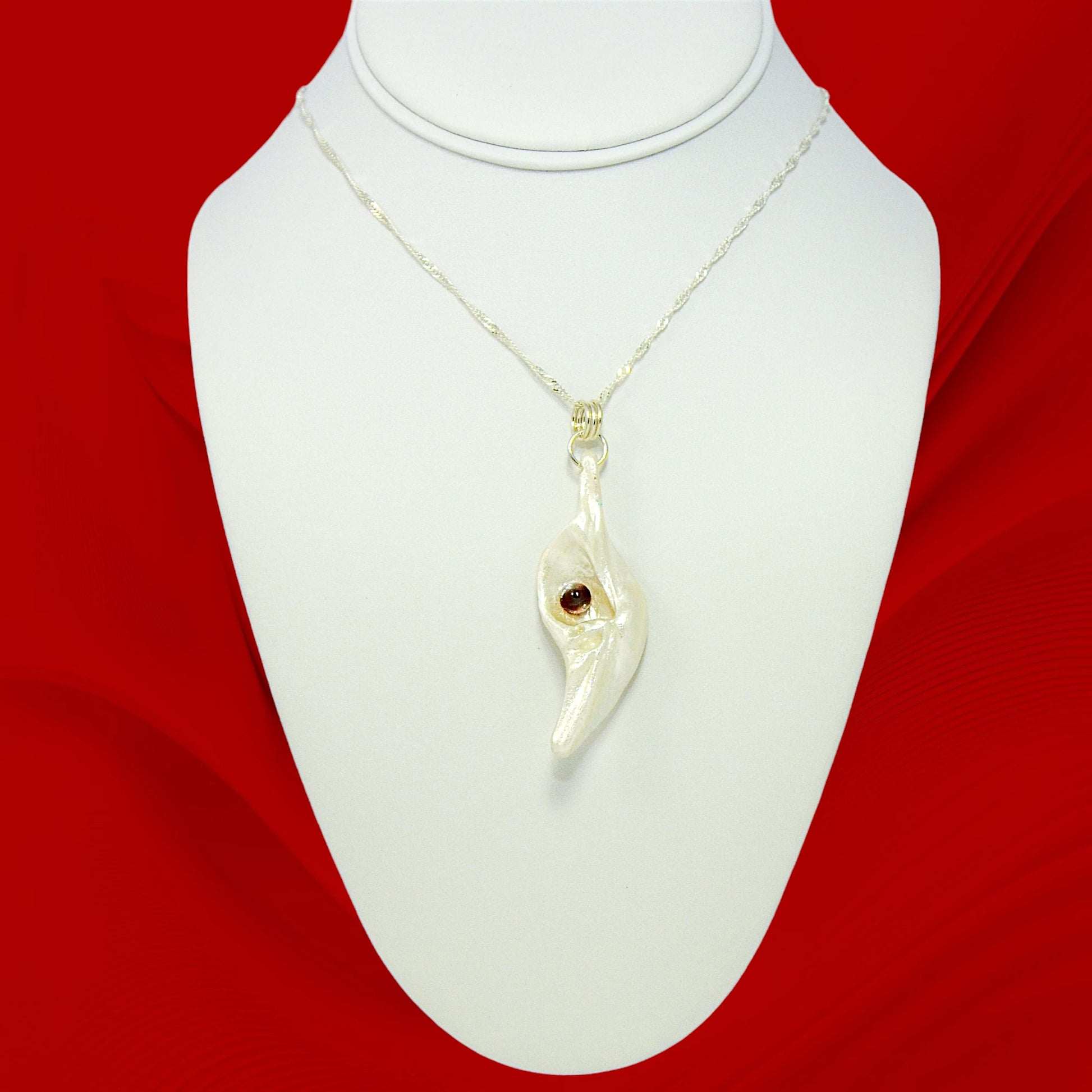 Pomegranate natural seashell pendant is adorned with a stunning Garnet gemstone.