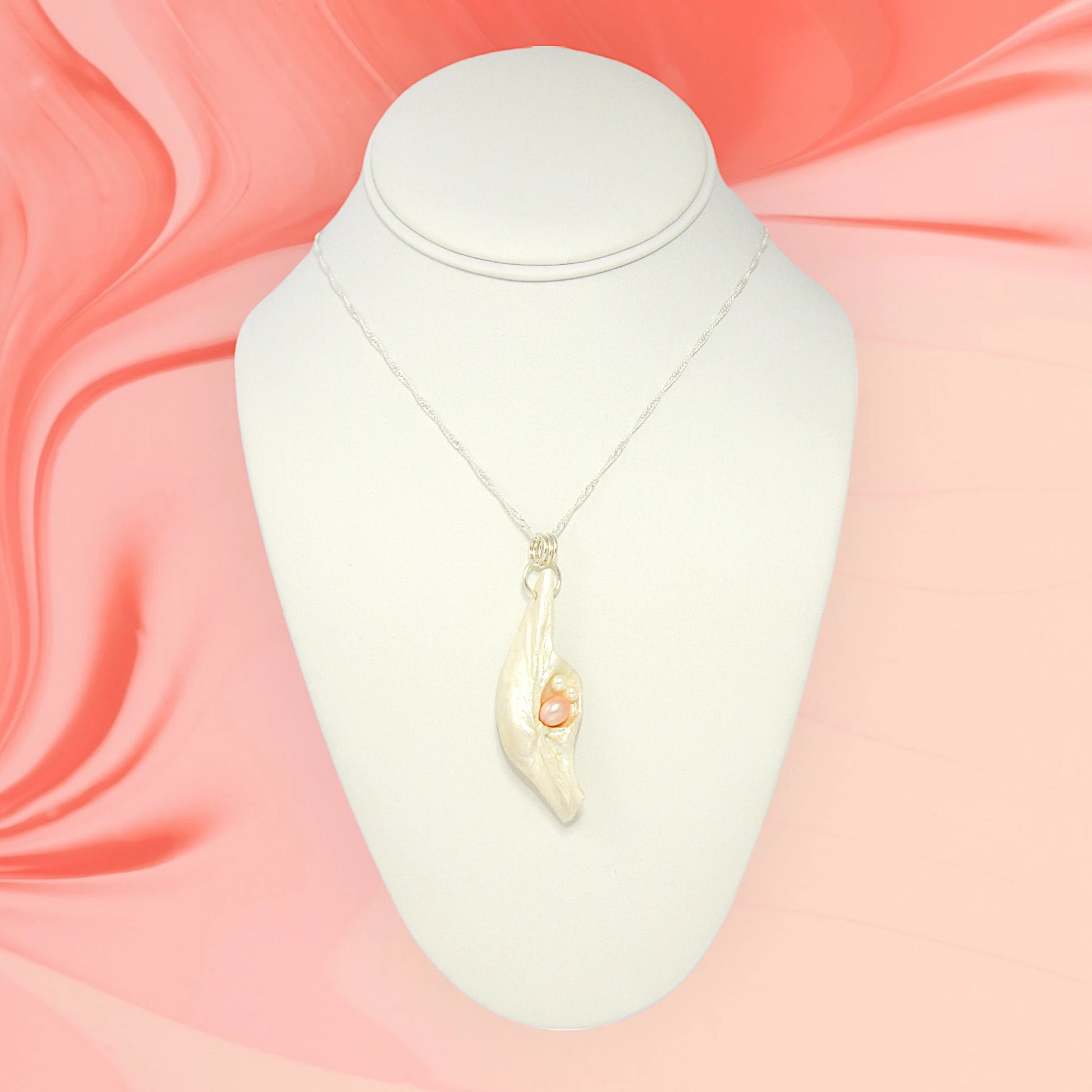 This natural seashell pendant has a real 7-8mm pink freshwater pearl and two baby pearls.