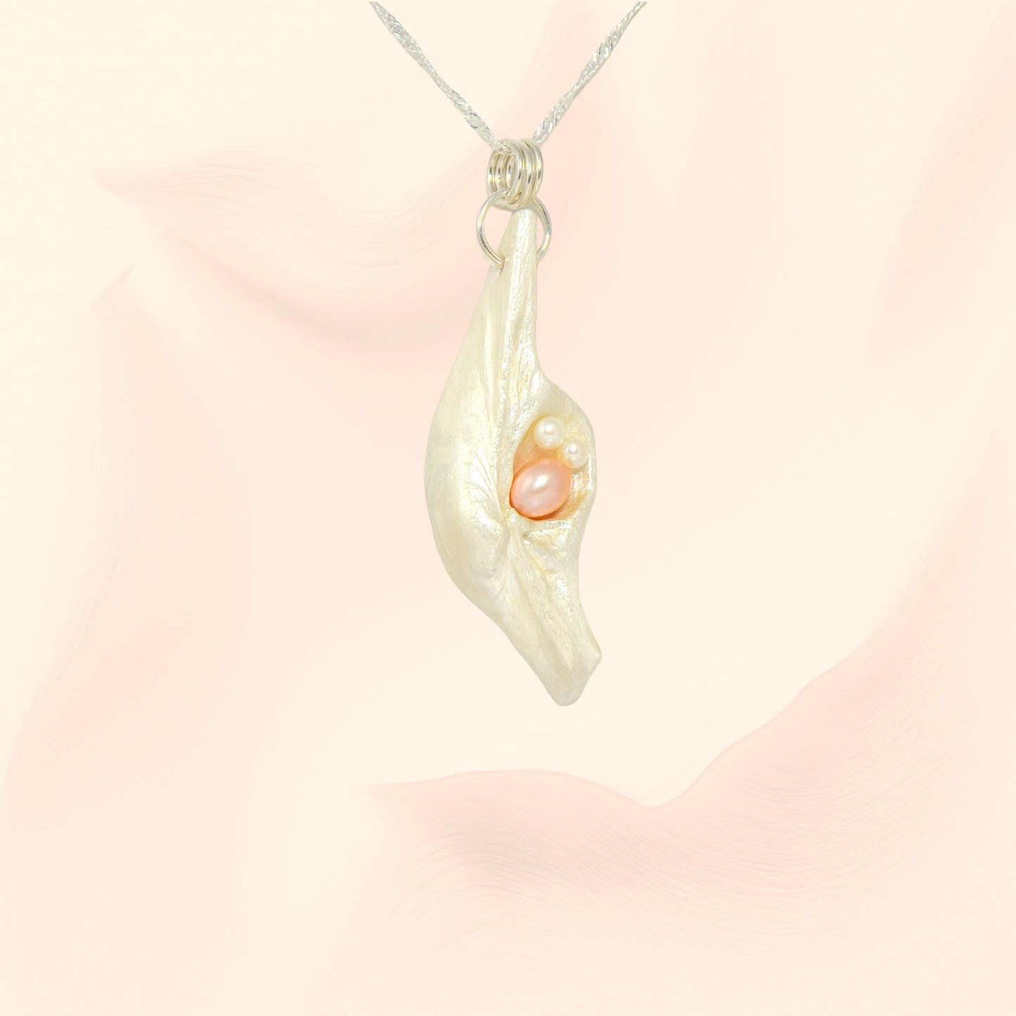 This natural seashell pendant has a real 7-8mm pink freshwater pearl and two baby pearls.