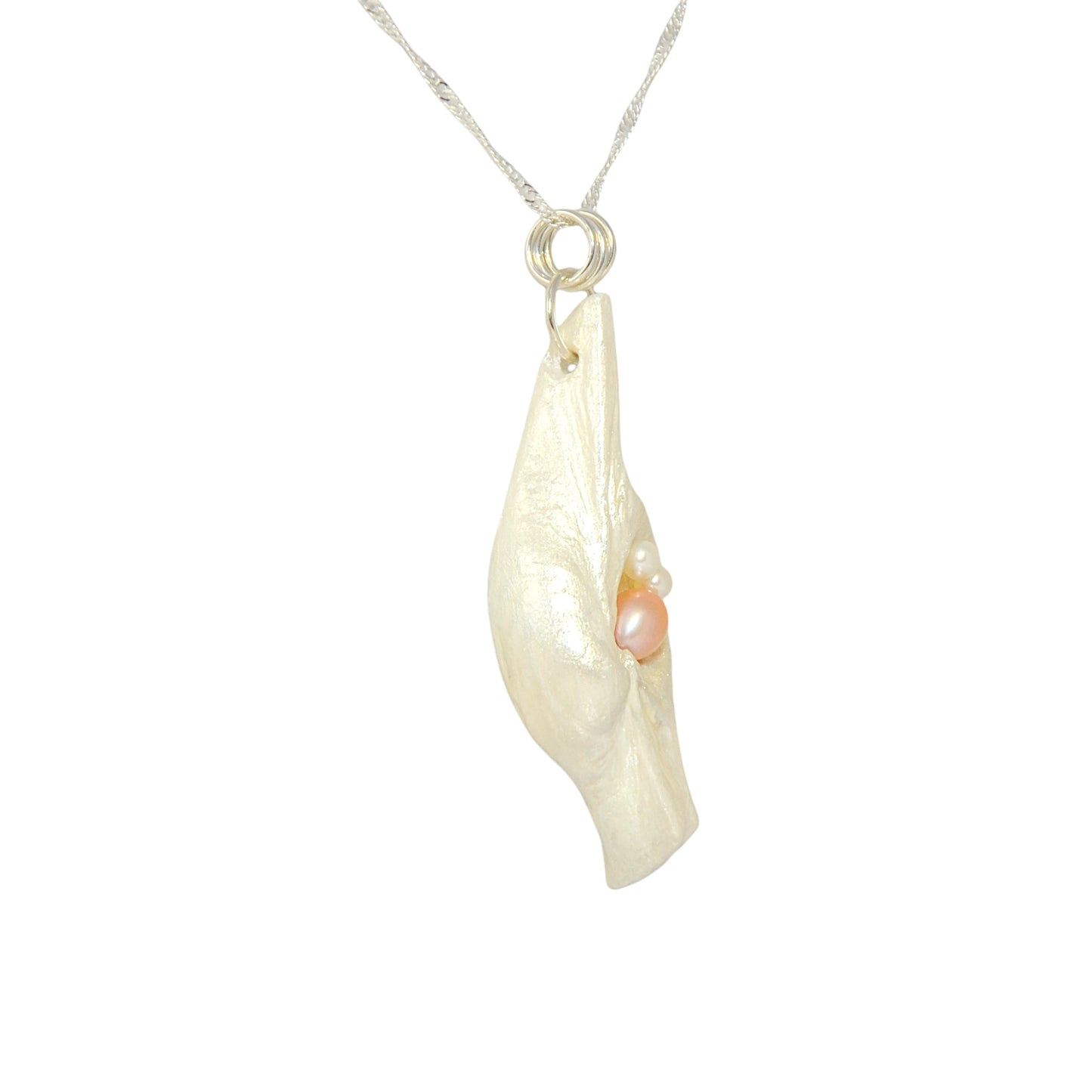 This natural seashell pendant has a real 7-8mm pink freshwater pearl and two baby pearls. The pendant is turned so the viewer can see the right side of the pendant.