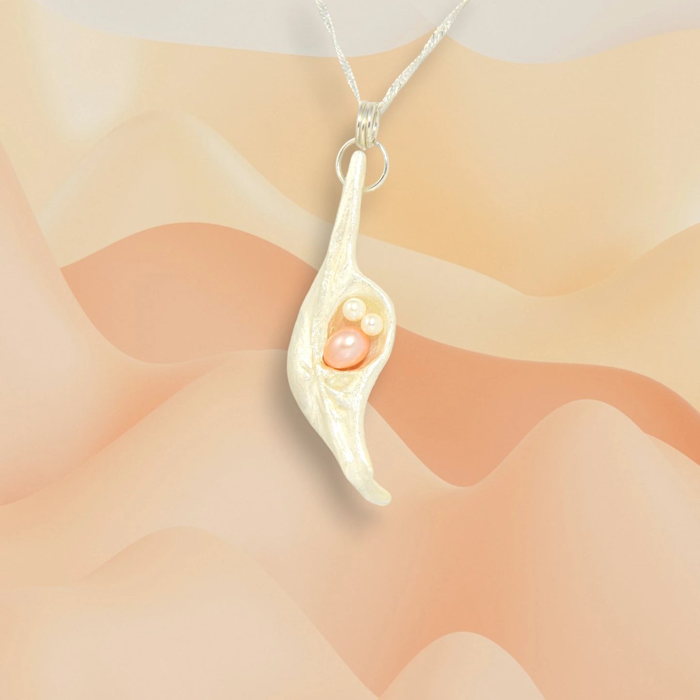This natural seashell pendant has a real 7-8mm pink freshwater pearl and two baby pearls. 