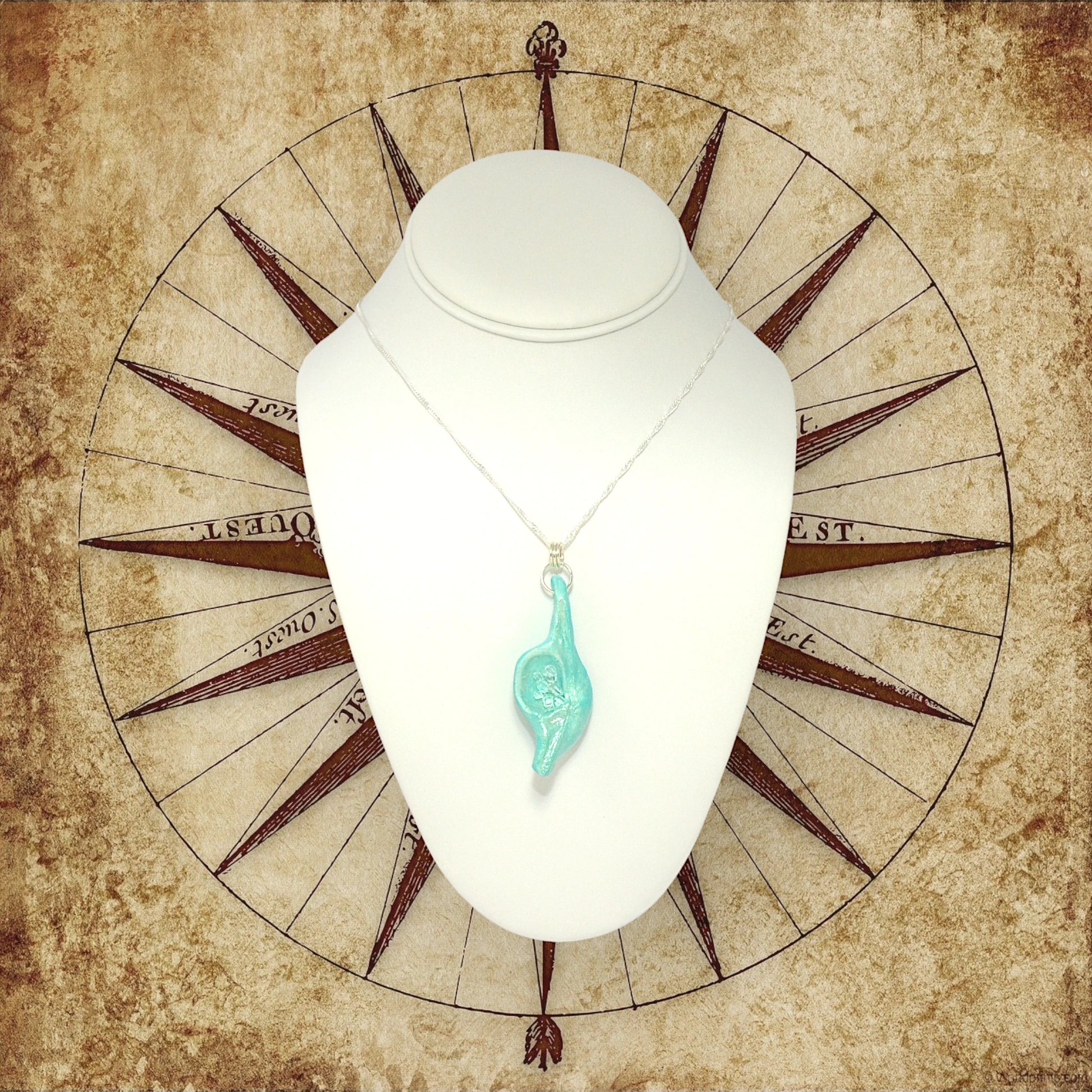 Diamond Mine Pendant is named for the eight herkimer diamonds that enhance the beauty of this gorgeous pendant! The pendant is shown hanging on a white necklace displayer with an old world map in the background.