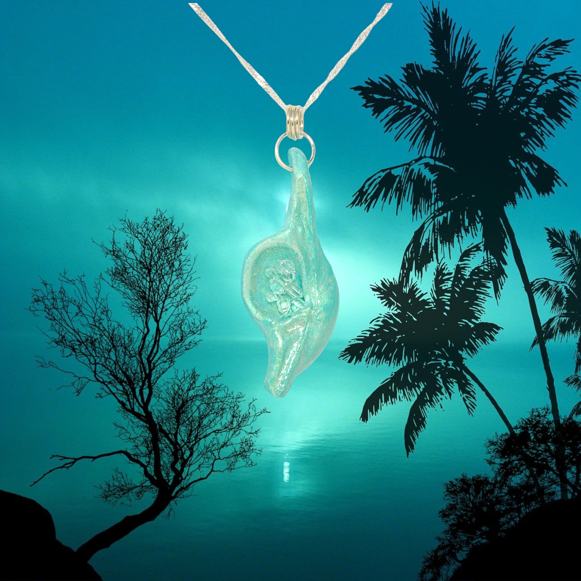 Diamond Mine Pendant is named for the eight herkimer diamonds that enhance the beauty of this gorgeous pendant!  The pendant is shown hanging from a chain over a moon lit ocean with trees around.