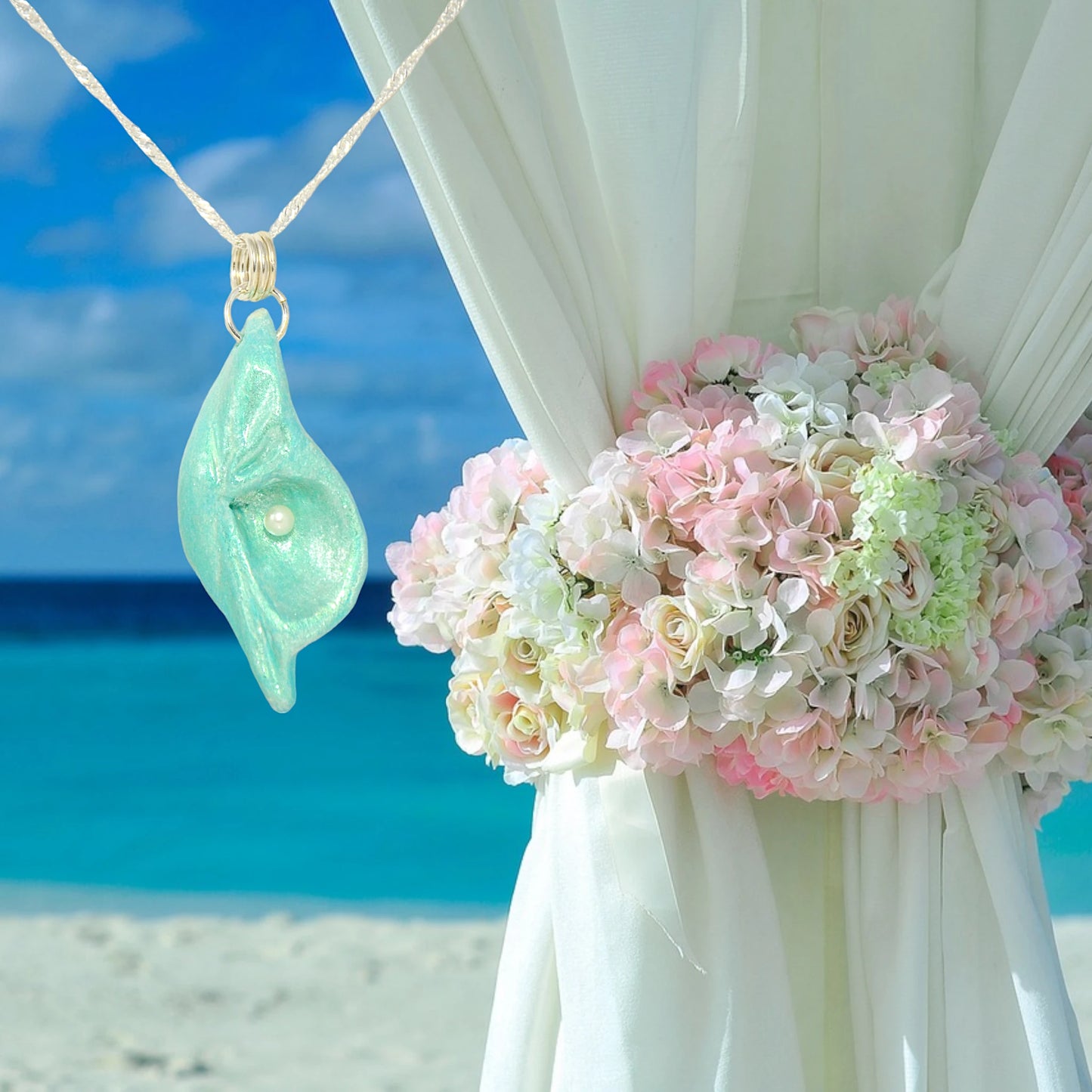 Ocean Pearl natural seashell pendant has a  real freshwater baby pearl.  The pendant is shown with the ocean in the background and a floral bouquet.