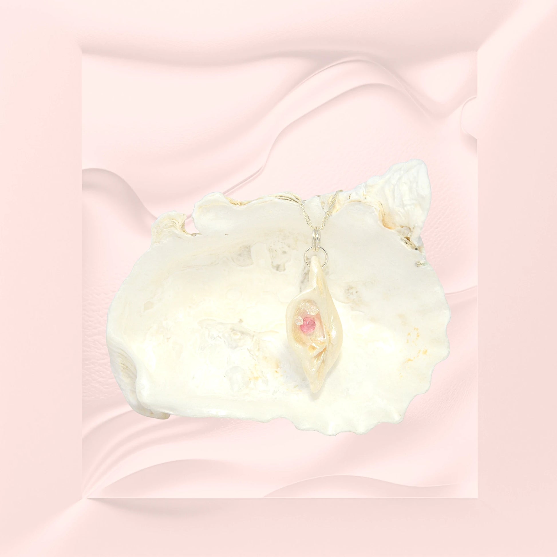 This natural seashell pendant has Pink Tourmaline gemstone and three Herkimer Diamonds that compliments the pendant. The pendant is shown on a larger seashell on a creamy pink background.