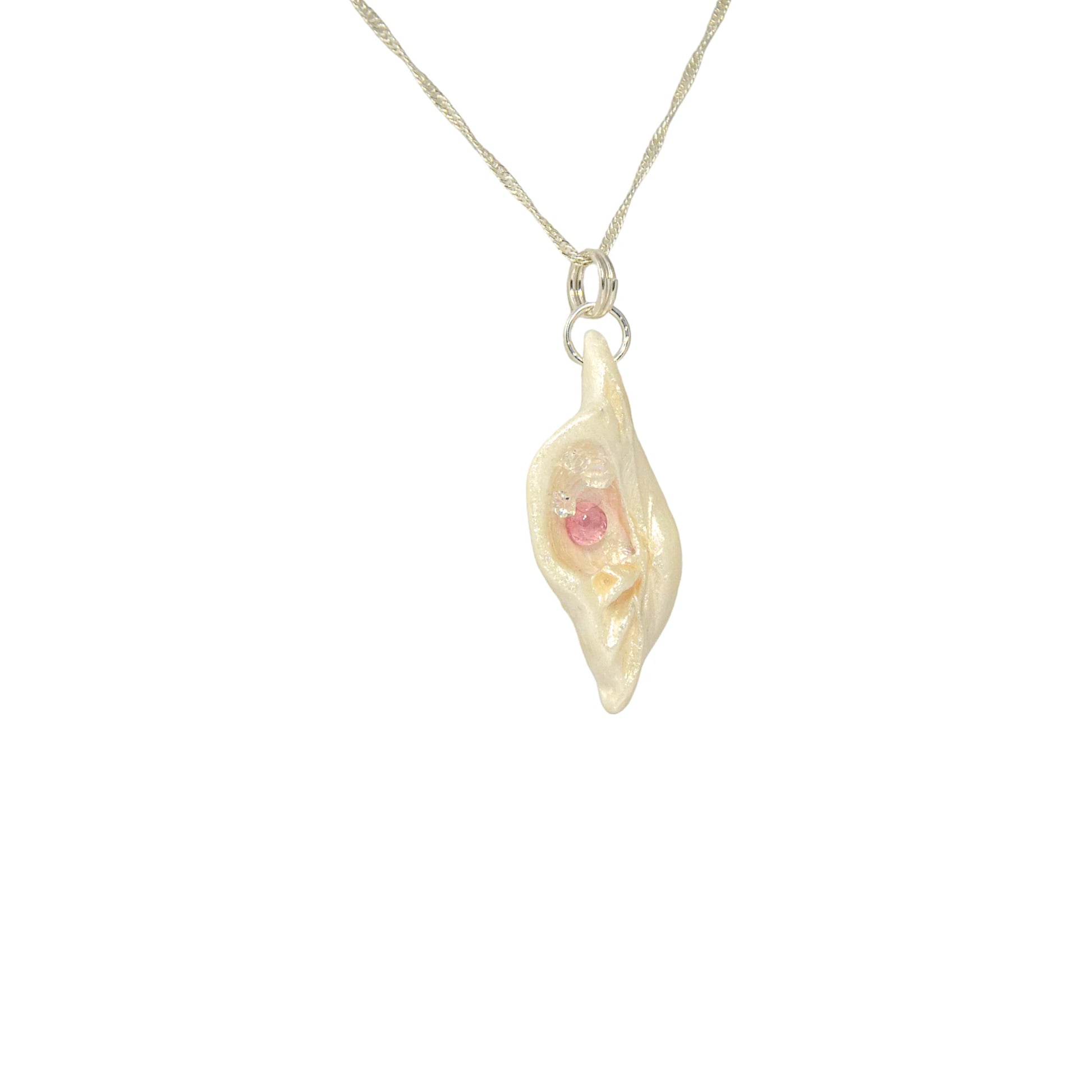 This natural seashell pendant has Pink Tourmaline gemstone and three Herkimer Diamonds that compliments the pendant. The pendant is shown turned so the viewer can see the right side of the pendant.
