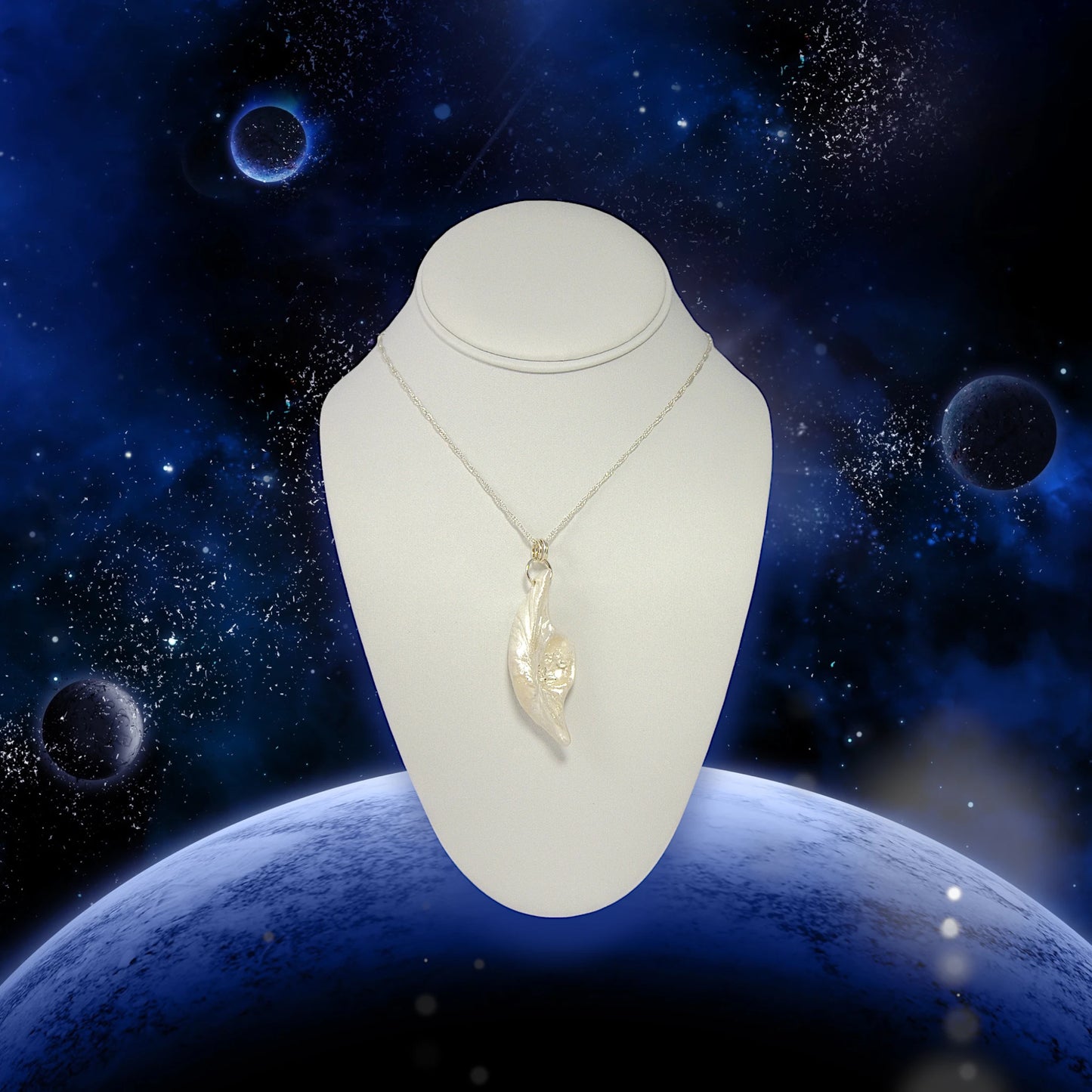 Beautiful pendant called Clarity.  Clarity is a natural seashell from the beach of Vancouver island.with seven herkimer diamonds. The pendant is shown on a white necklace displayer hanging from a chain.  The background is of outer space in blue with stars, moons, and planets.