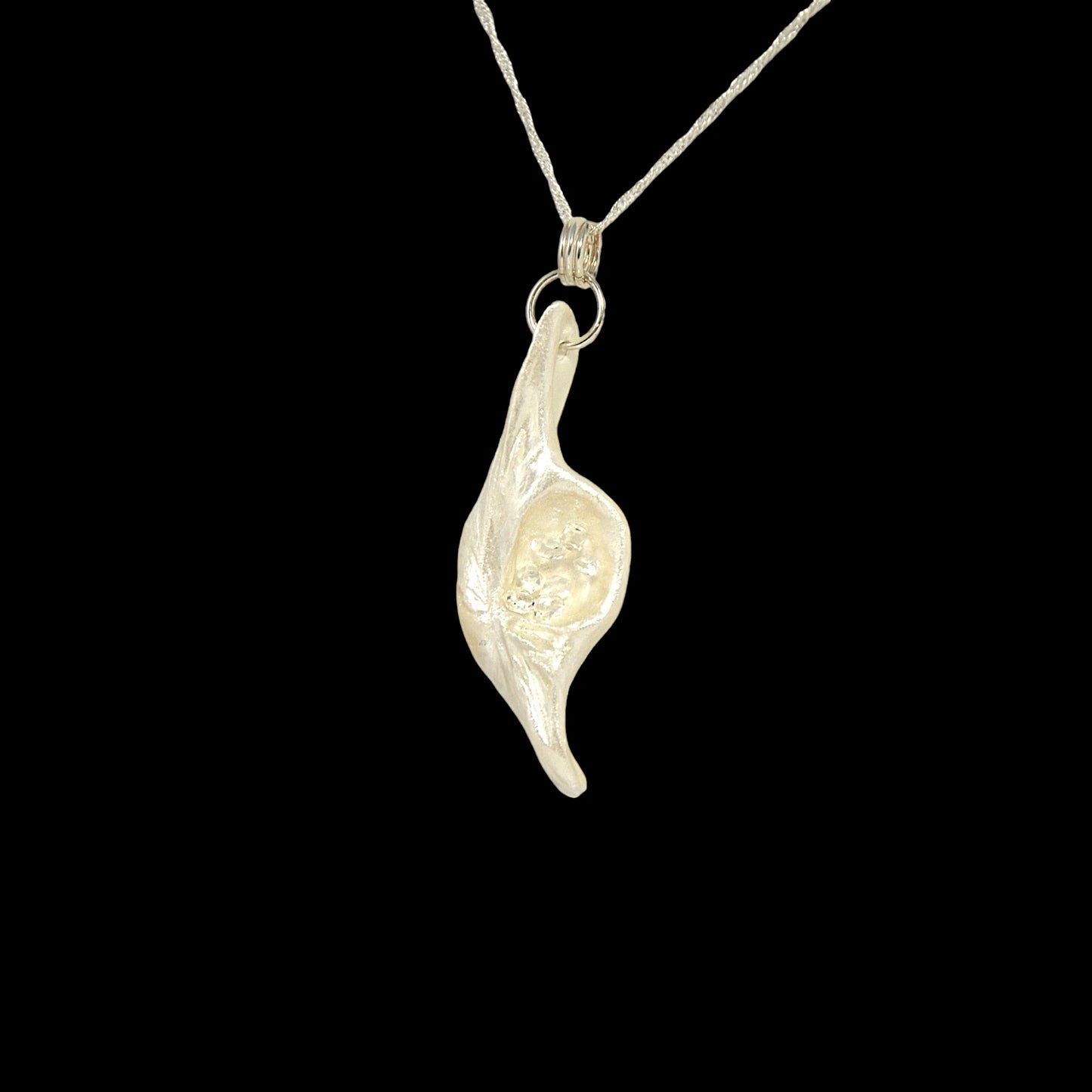 Beautiful pendant called Clarity.  Clarity is a natural seashell from the beach of Vancouver island.with seven herkimer diamonds.  The pendant is turned to the right to show the viewer the shape of the pendant and the herkimer diamonds.