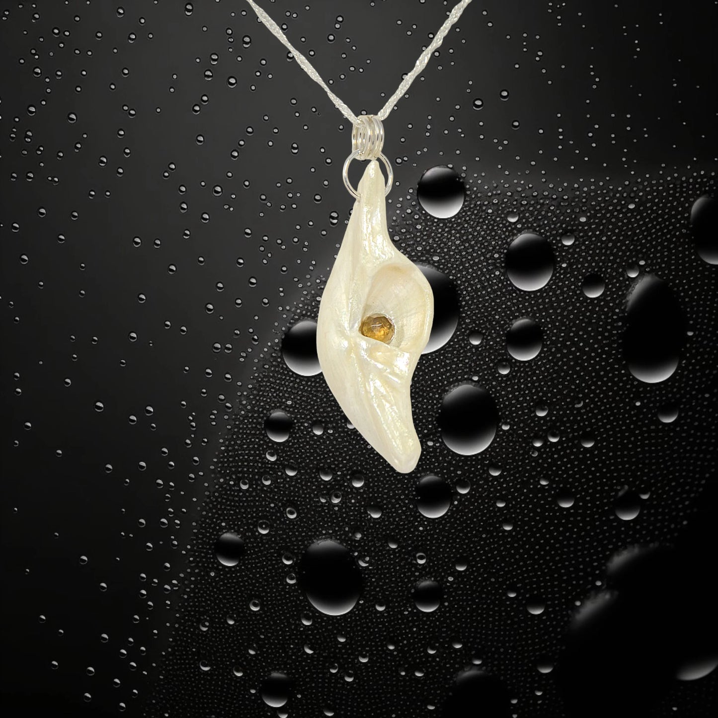 Seer is a natural seashell pendant with a beautiful 5mm rose cut Smokey Quartz compliments the pendant. The pendant is in front of a black background with water bubbles.