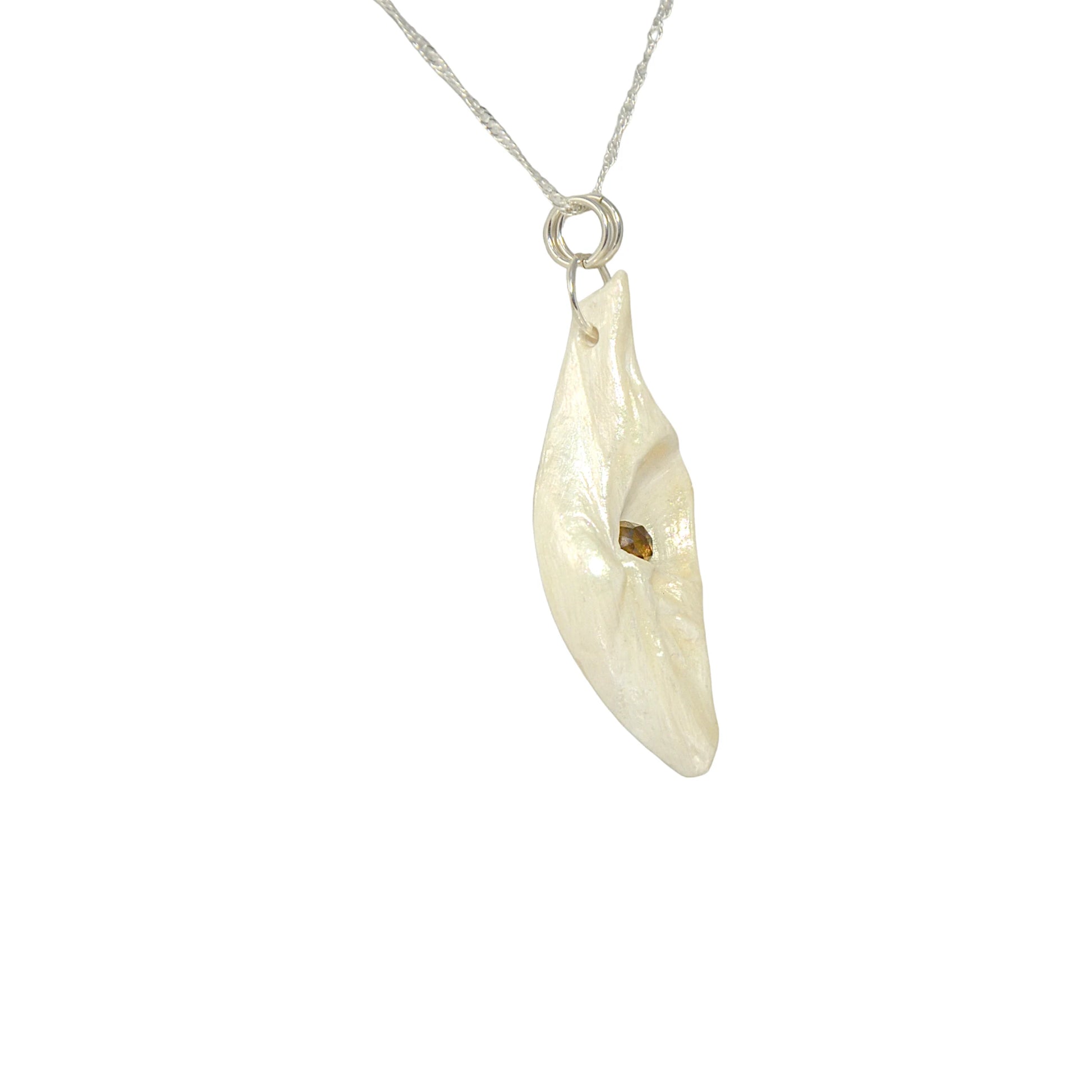 Seer is a natural seashell pendant with a beautiful 5mm rose cut Smokey Quartz compliments the pendant. the pendant is turned so the viewer can see the right side of the pendant.