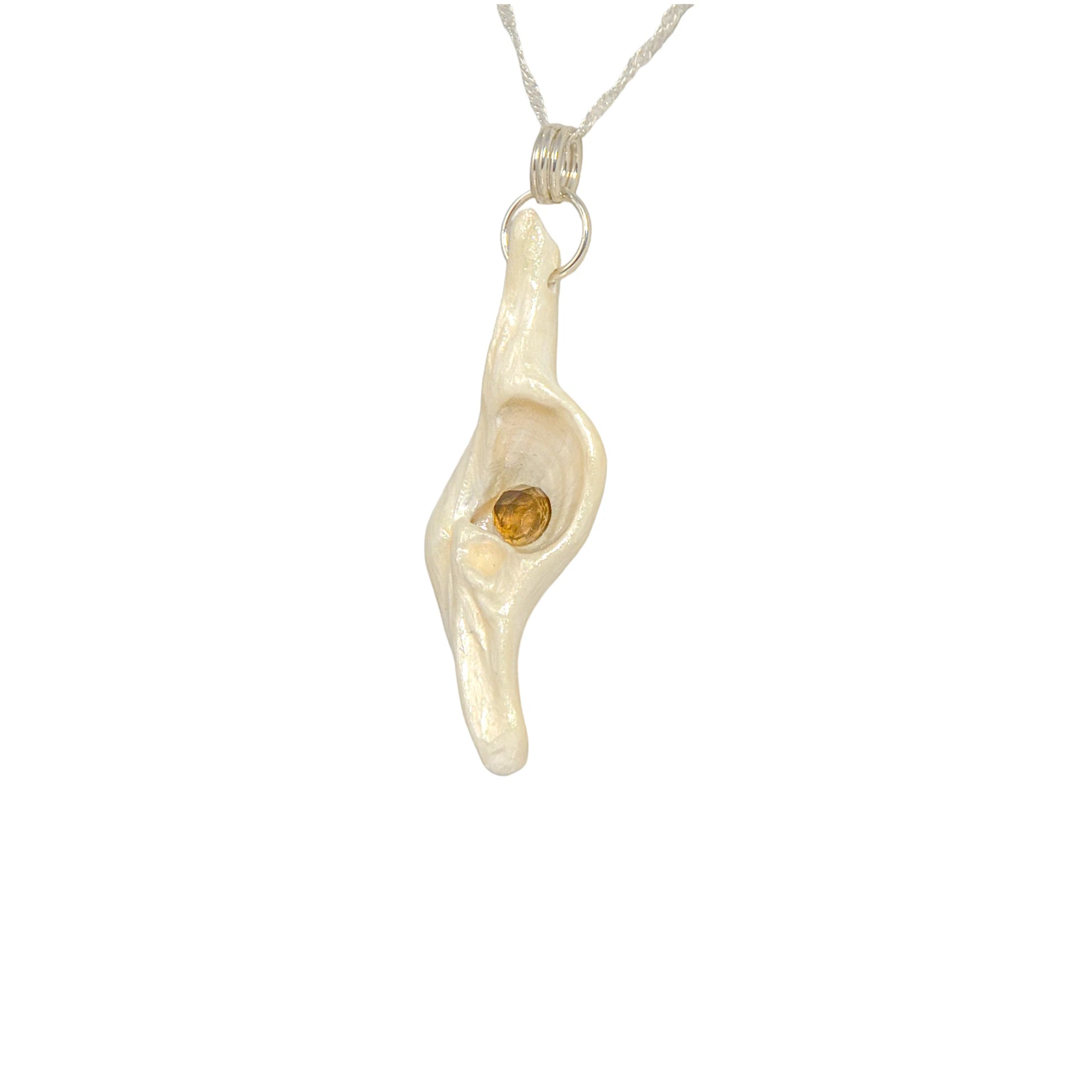 Seer is a natural seashell pendant with a beautiful 5mm rose cut Smokey Quartz compliments the pendant. The pendant is shown turned so the viewer can see the left side of the pendant.