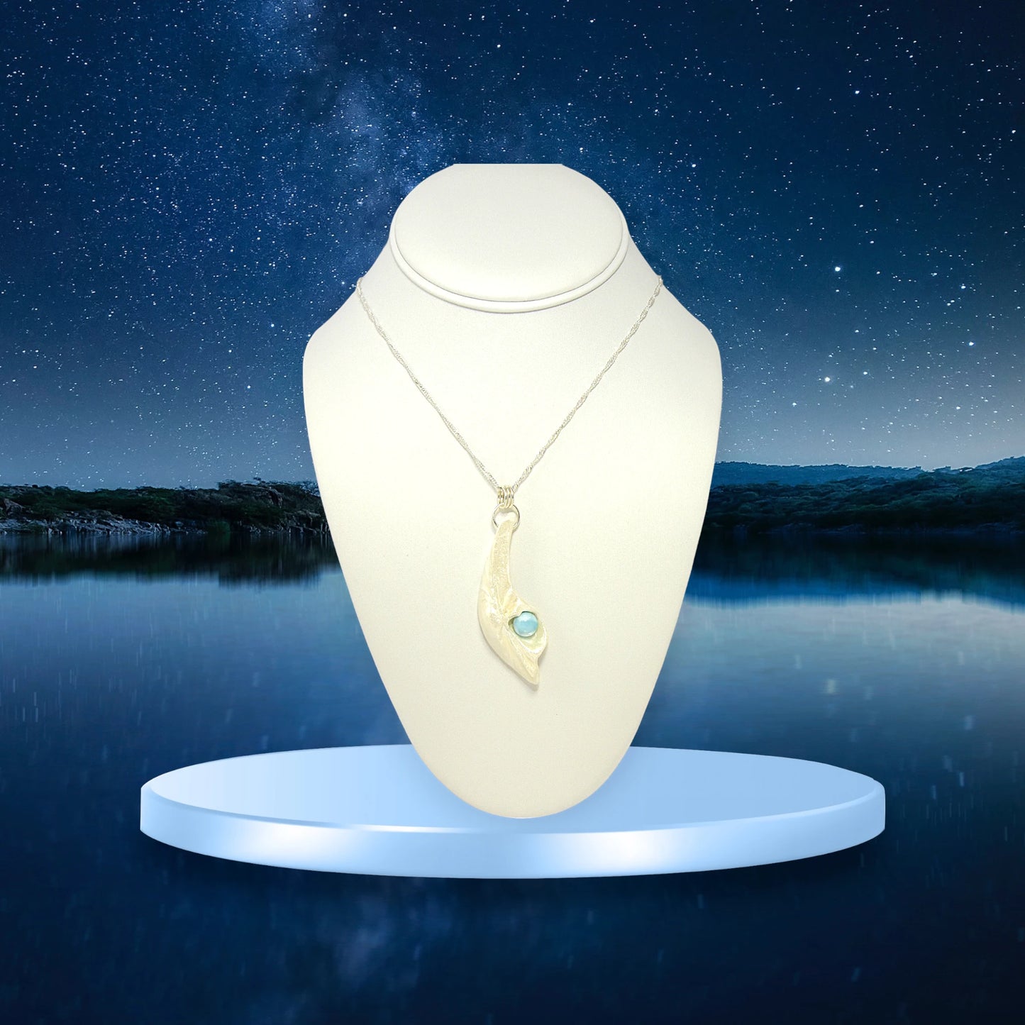 Larimar Moon Natural seashell a beautiful 10 mm Round Larimar Gemstone compliments the pendant. The pendant is shown on a white necklace displayer with a starry night background.
