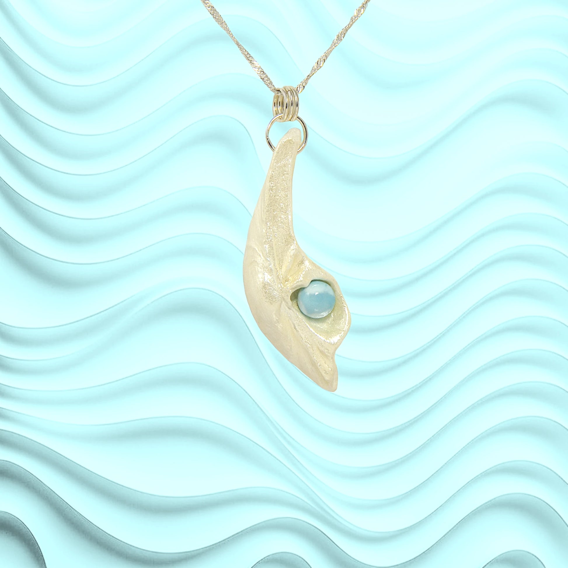 Larimar Moon Natural seashell a beautiful 10 mm Round Larimar Gemstone compliments the pendant.  A wavy blue background.