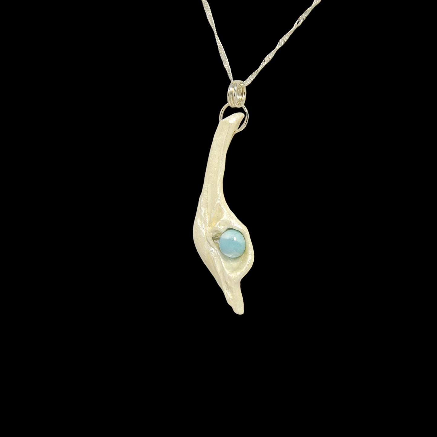 Larimar Moon Natural seashell a beautiful 10 mm Round Larimar Gemstone compliments the pendant. The pendant is shown turned so the viewer can see the left side of the pendant.