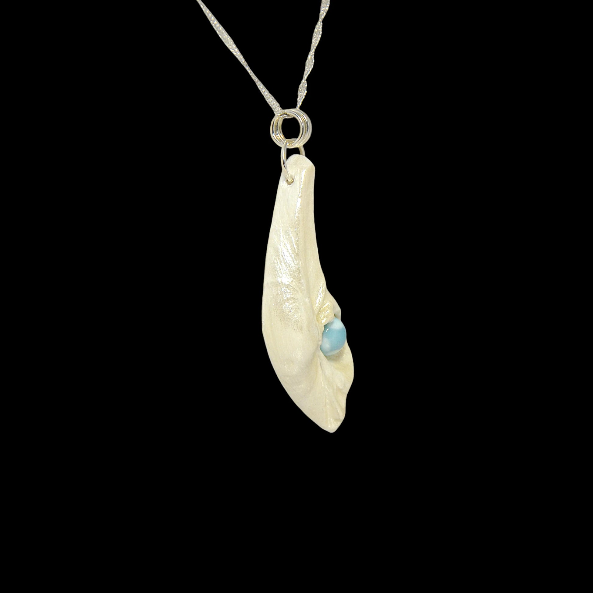 Larimar Moon Natural seashell a beautiful 10 mm Round Larimar Gemstone compliments the pendant. The pendant is shown turned so the viewer can see the right side of the pendant.