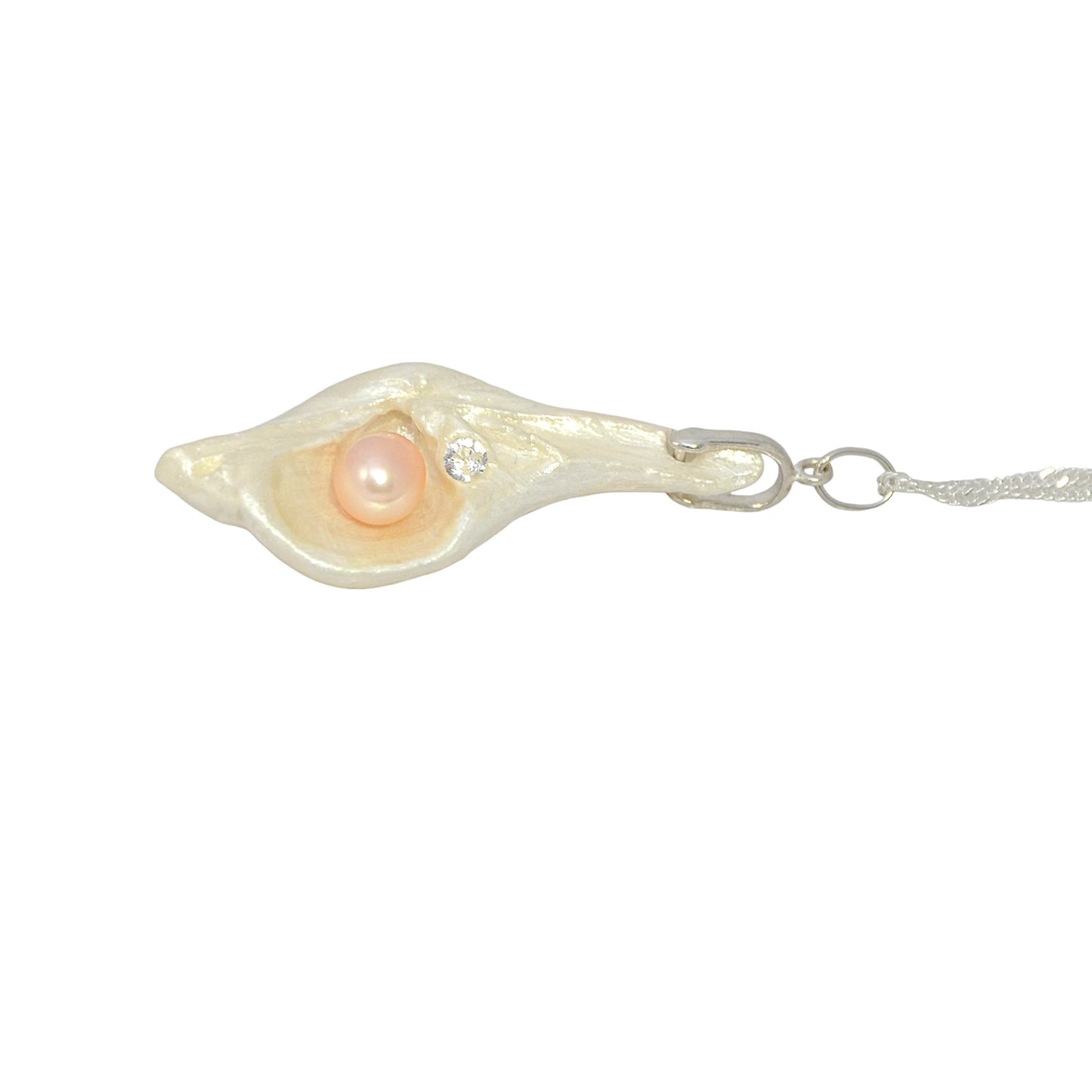 The pendant is laying on its side to show the viewer the pearl and faceted herkimer diamond.